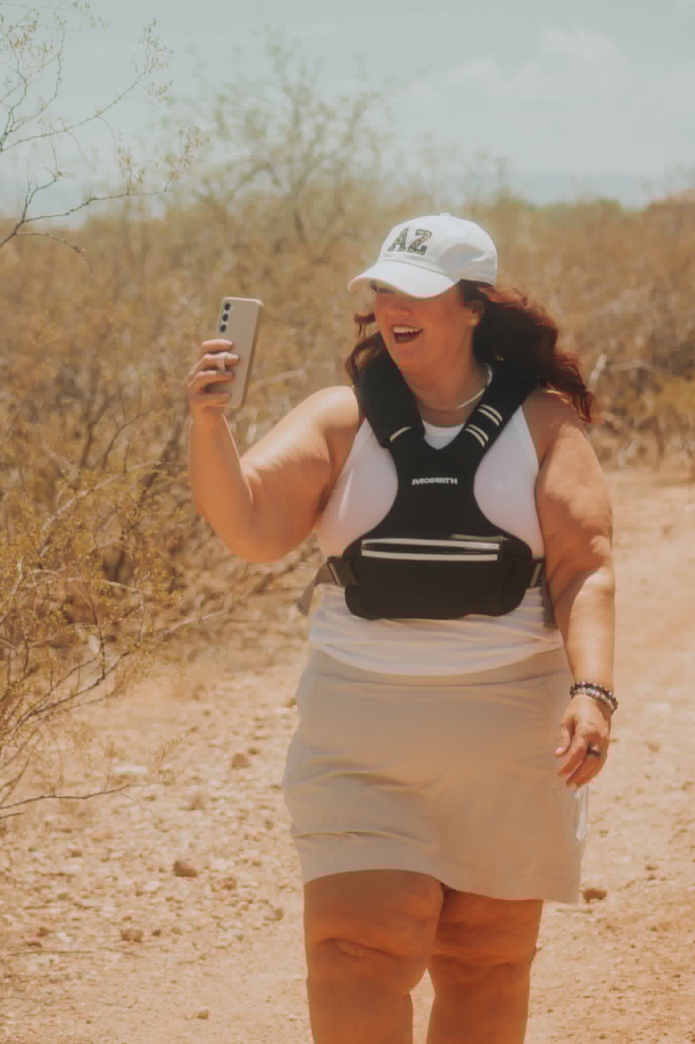 Melissa Anne hiking and filming on a desert trail