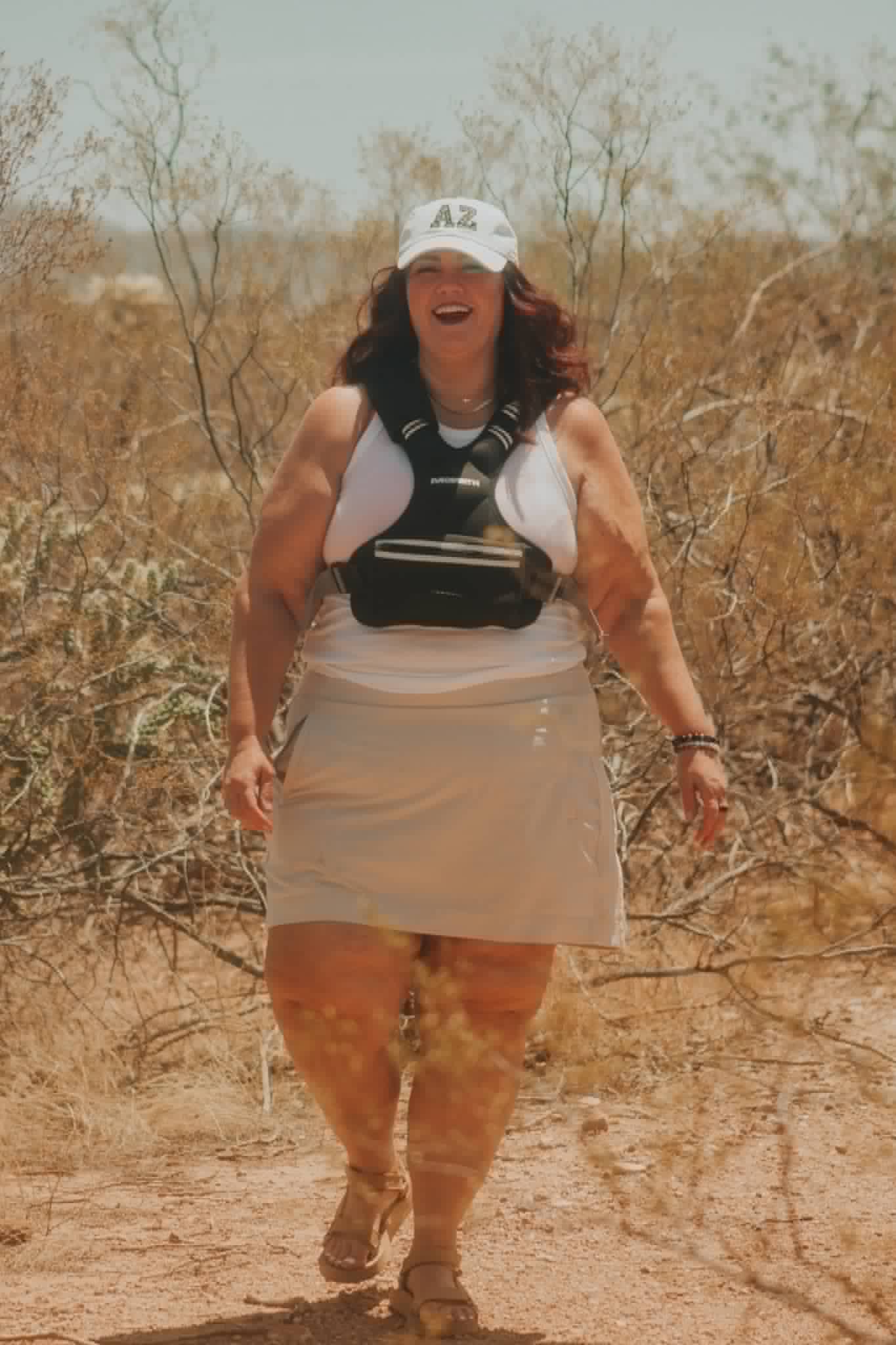 Melissa Anne walking and laughing on a desert trail